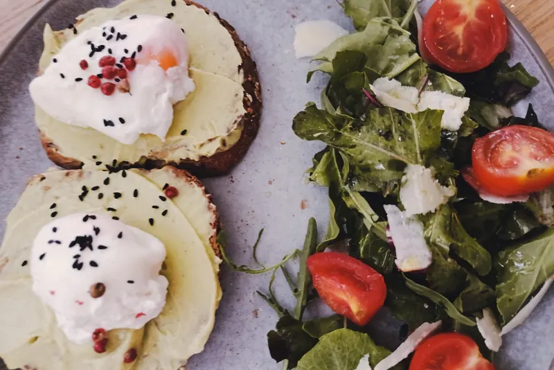 Avocado toast with poached eggs and rocket salad