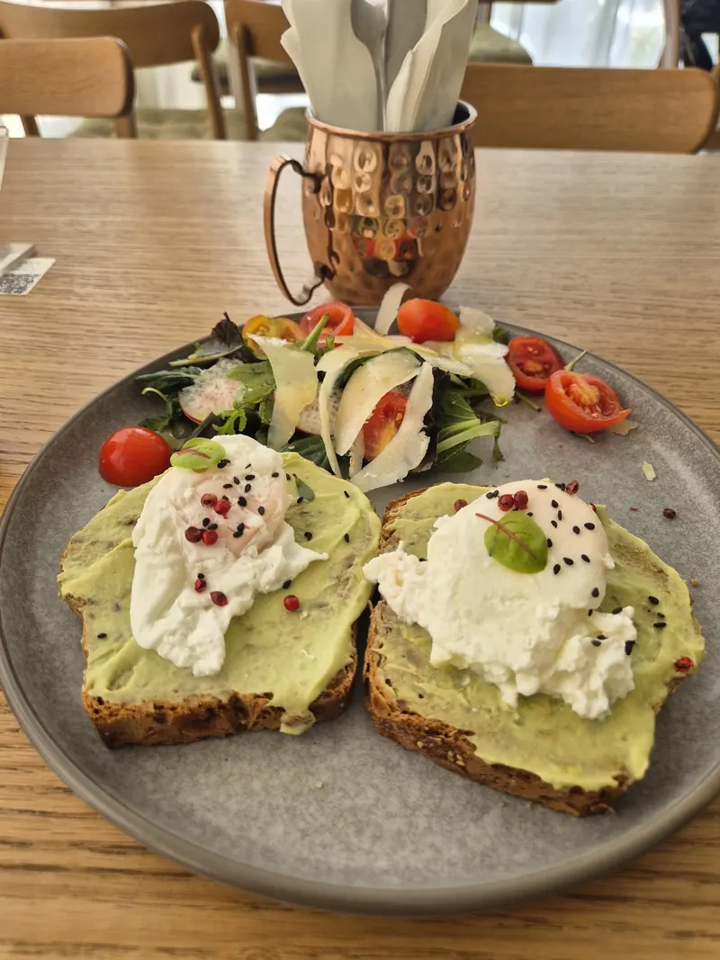 Avocado toast with poached eggs and a fresh salad