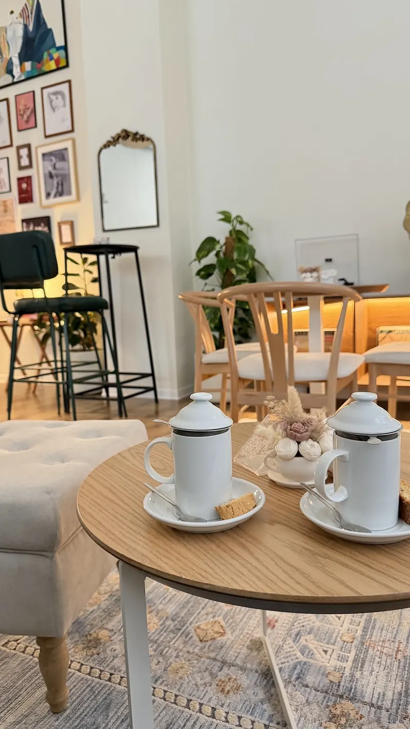 Two teapots on a small wooden table inside the café
