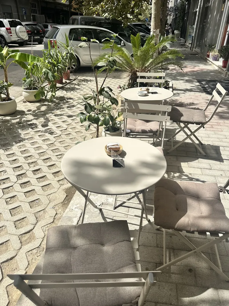 Outdoor tables on the shaded pavement terrace